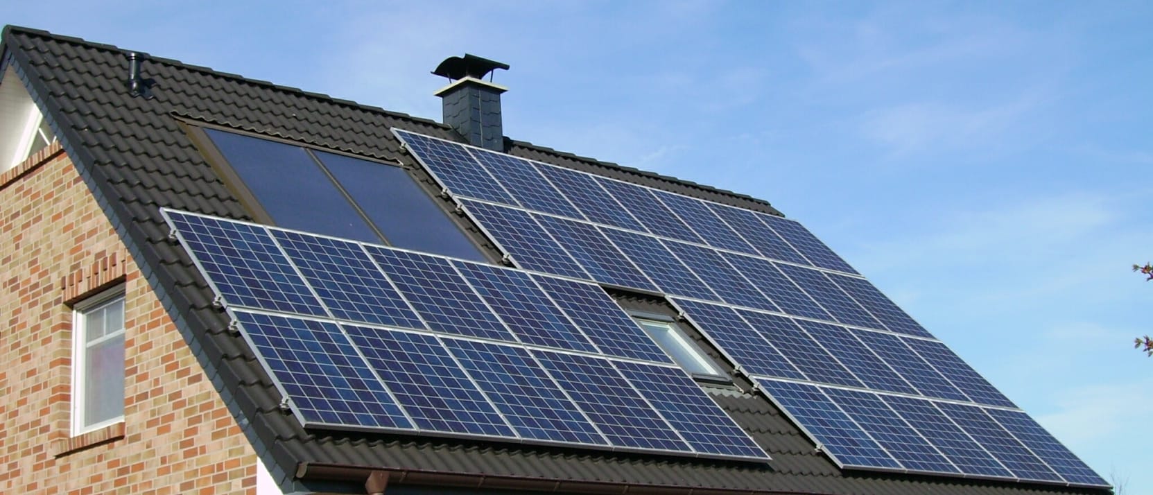 Hellend pannendak in antraciet met een groot veld blauwe zonnepanelen