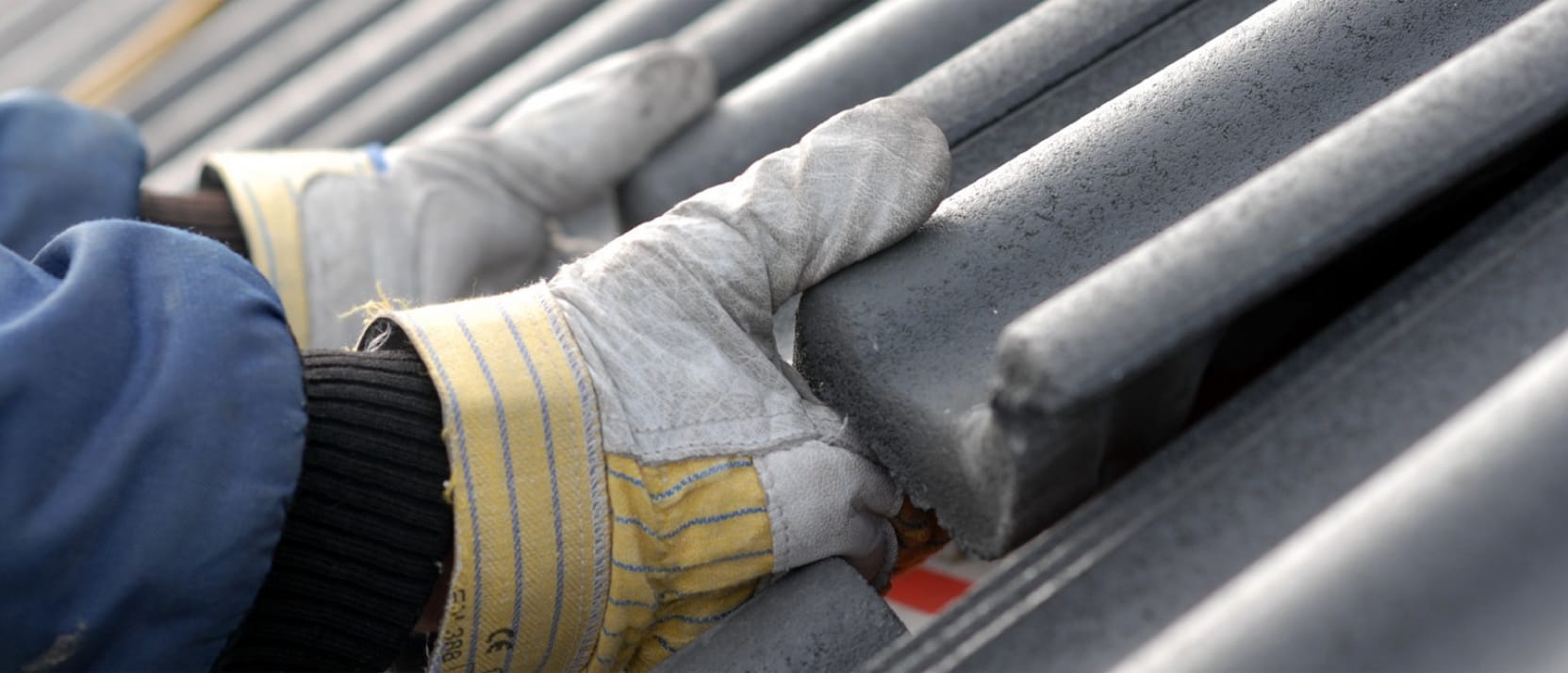 Dakwerker van ADW Messiaen plaatst een grijze betonnen nokpan met vakkundige precisie